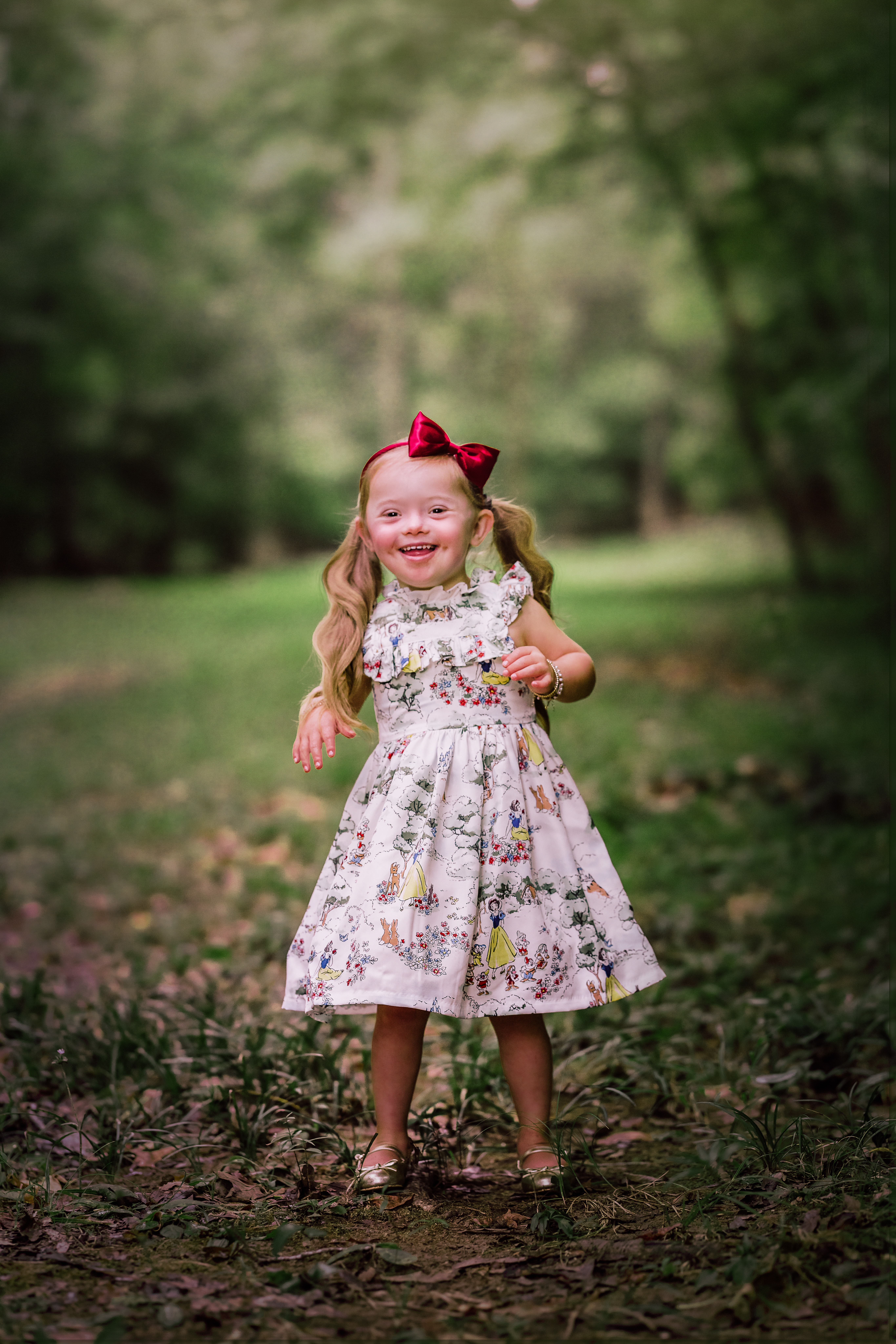 little girl with down syndrome playing in the forest