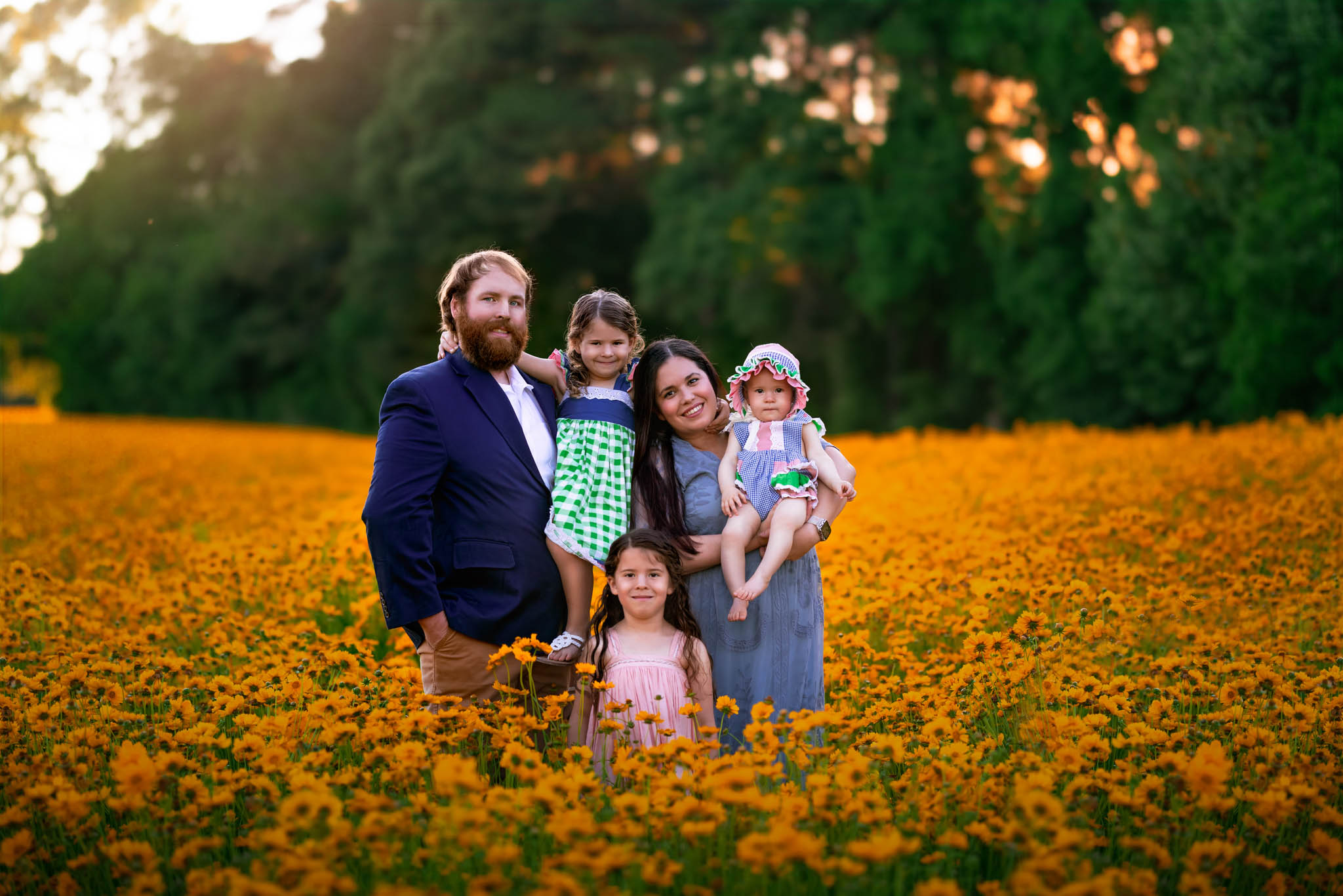 A family of five stand in a field of yellow flowers