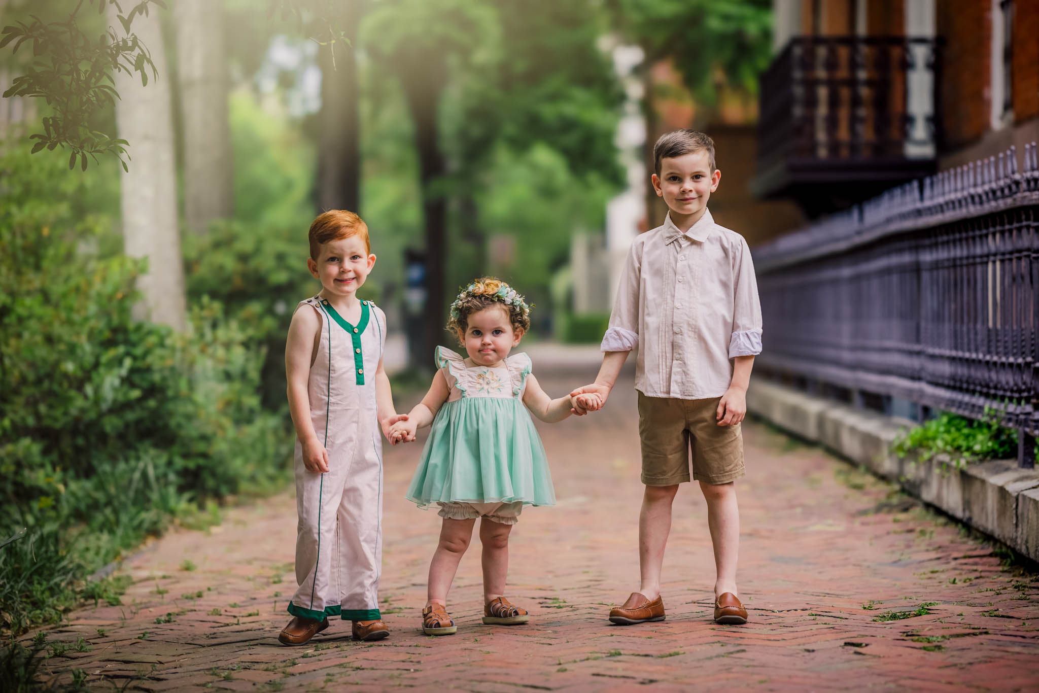 Three sibling stand in a brick path holding hands things to do in asheville with kids