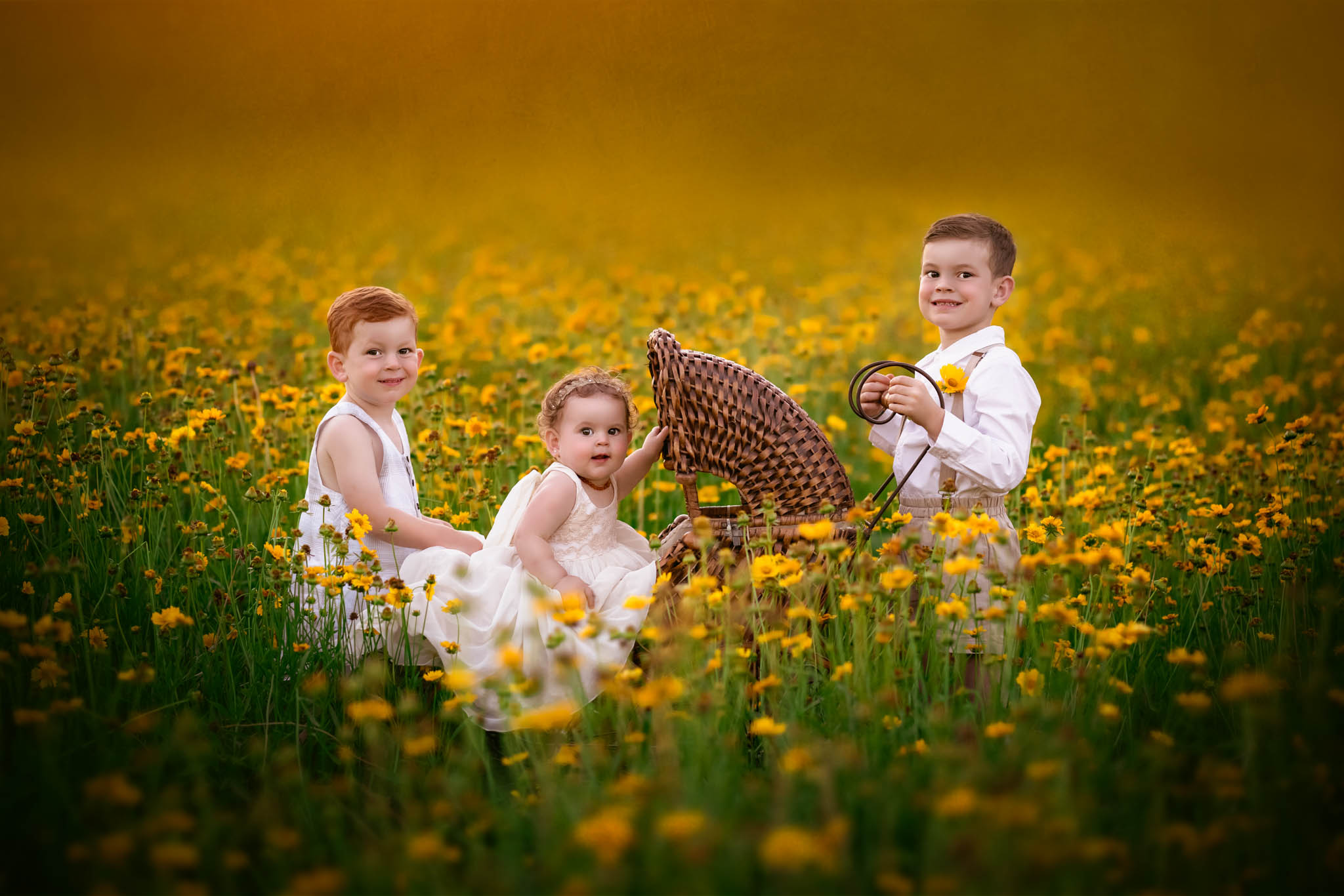 Three siblings play with a wicker baby carriage in a field of yellow flowers raleigh summer camps