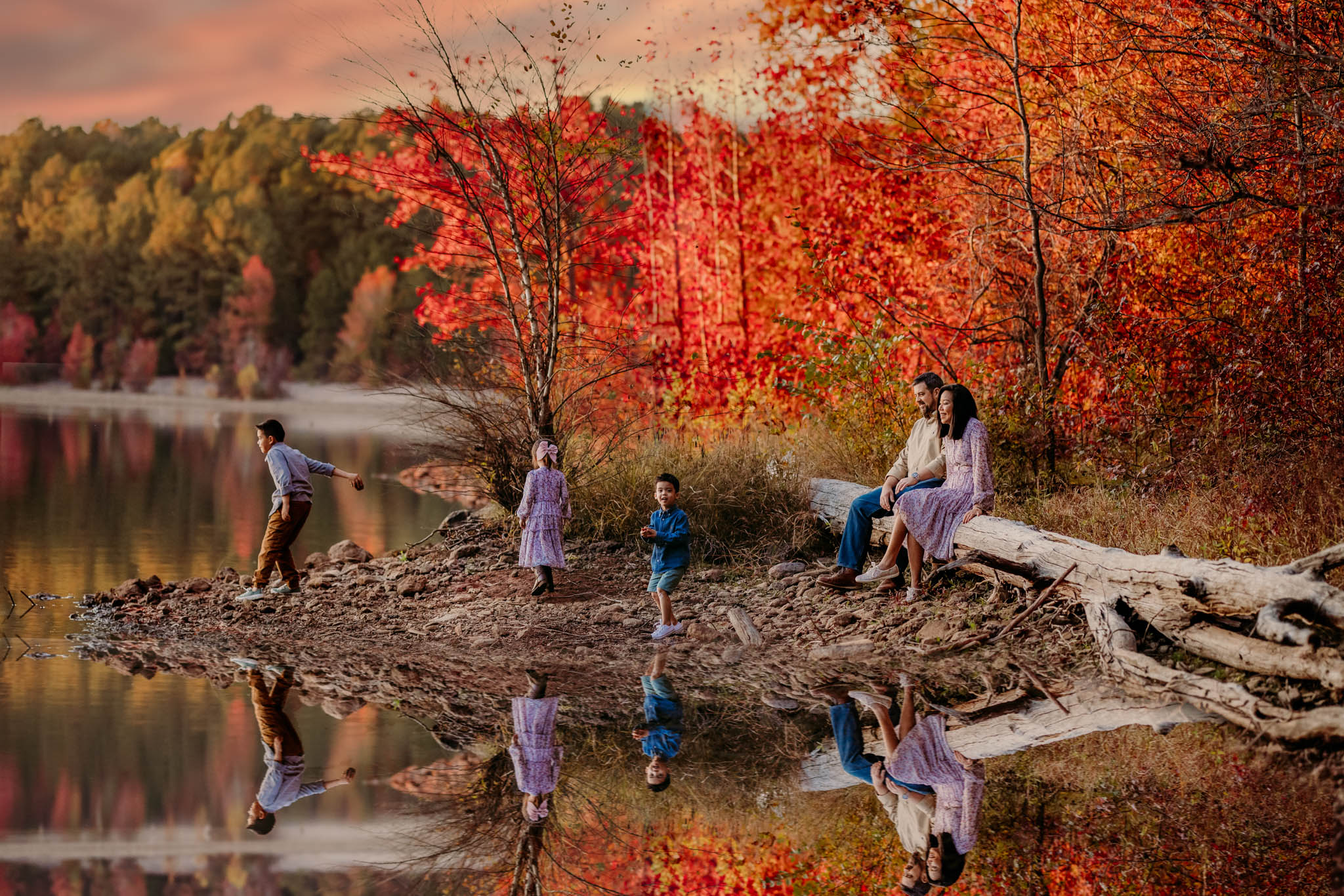a family next to the lake in autumn