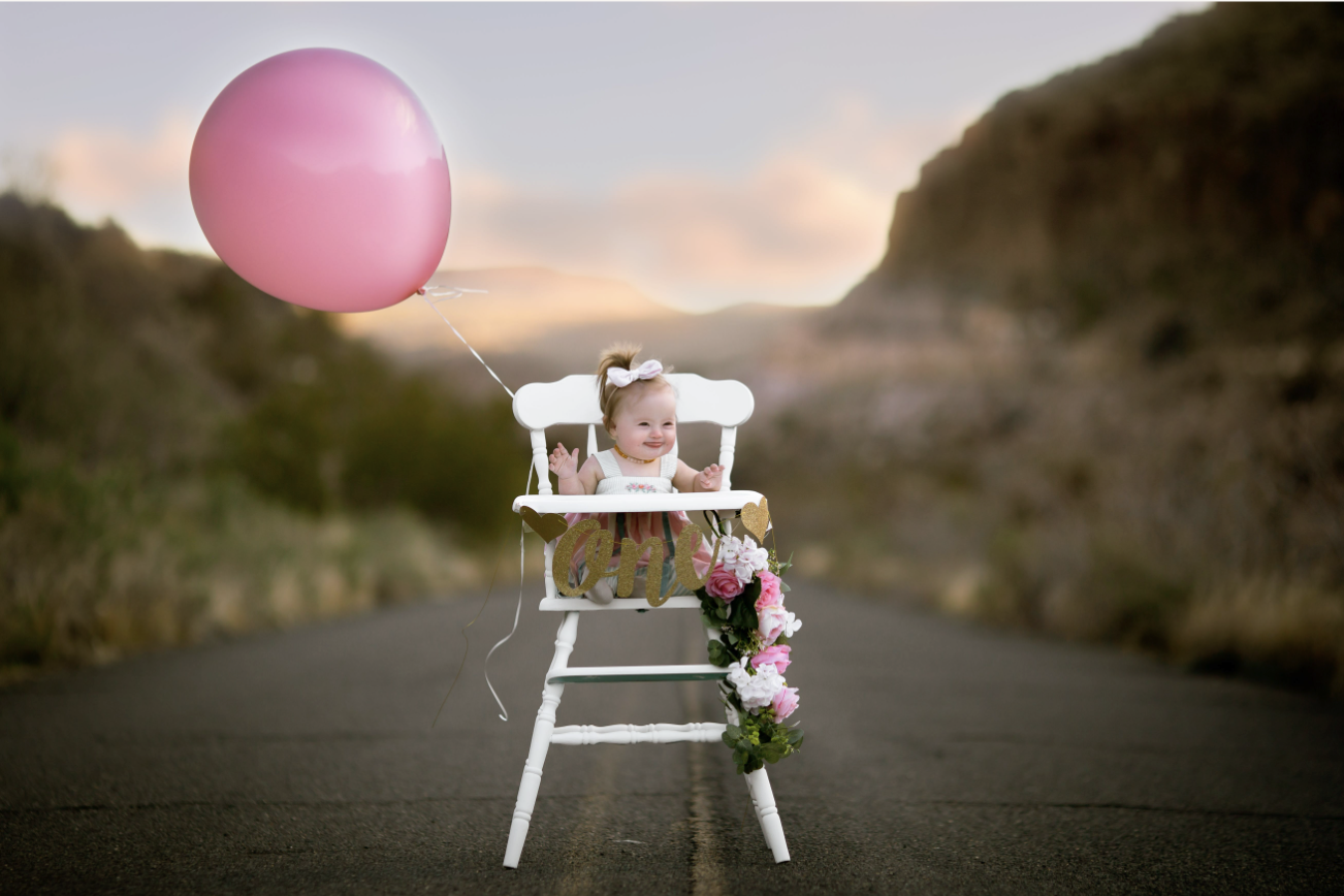 little girl with a birthday balloon on a roadway