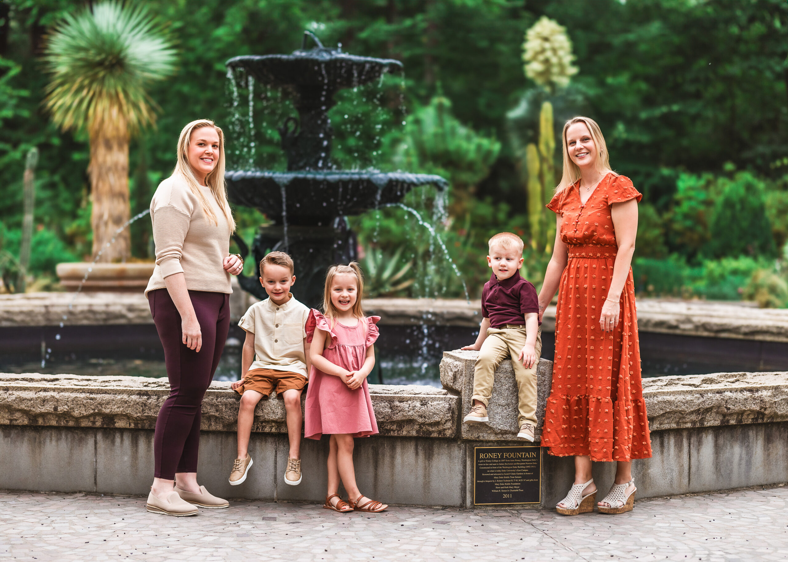 Family posed next to fountain duke gardens
