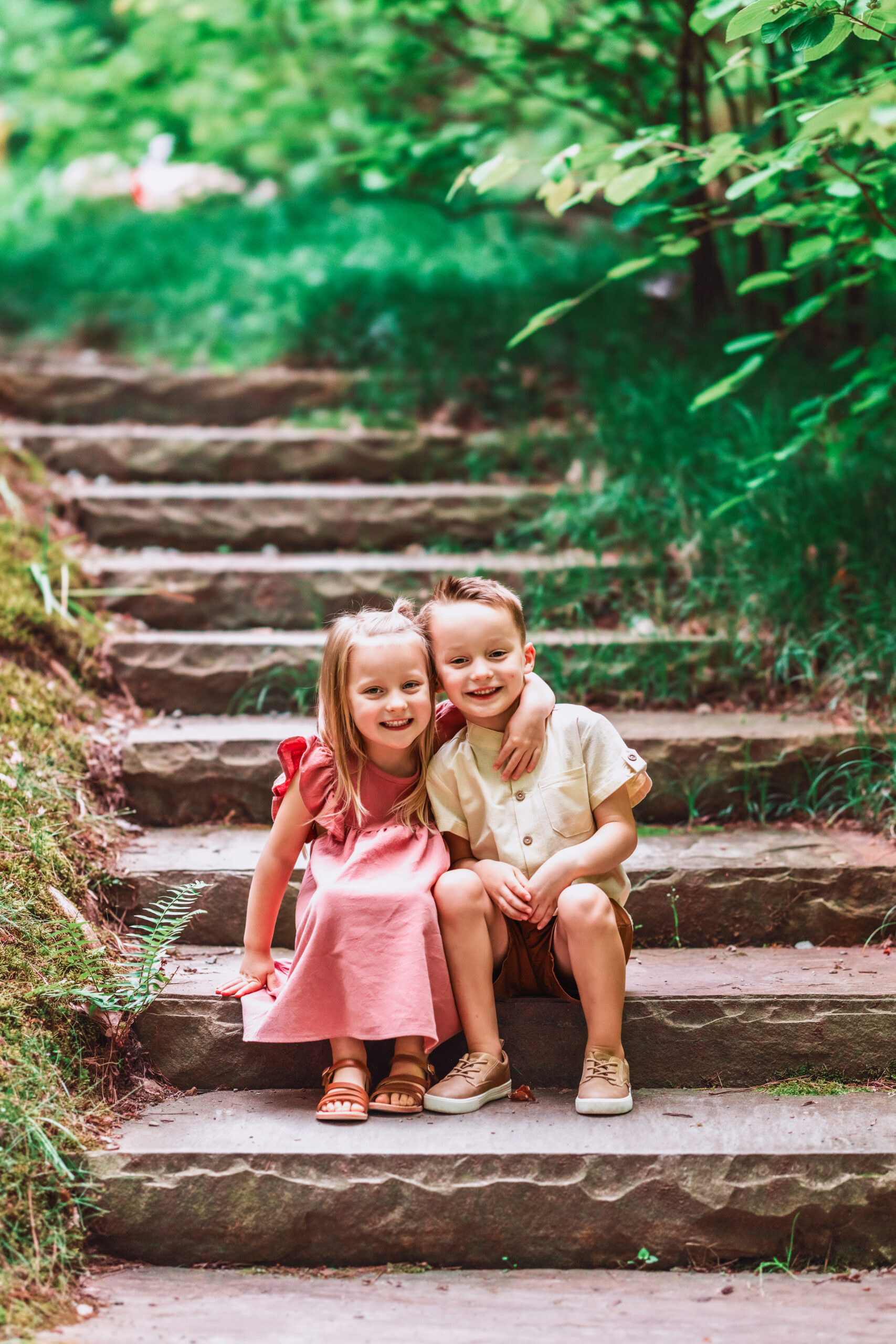 Twins boy and girl hugging on steps