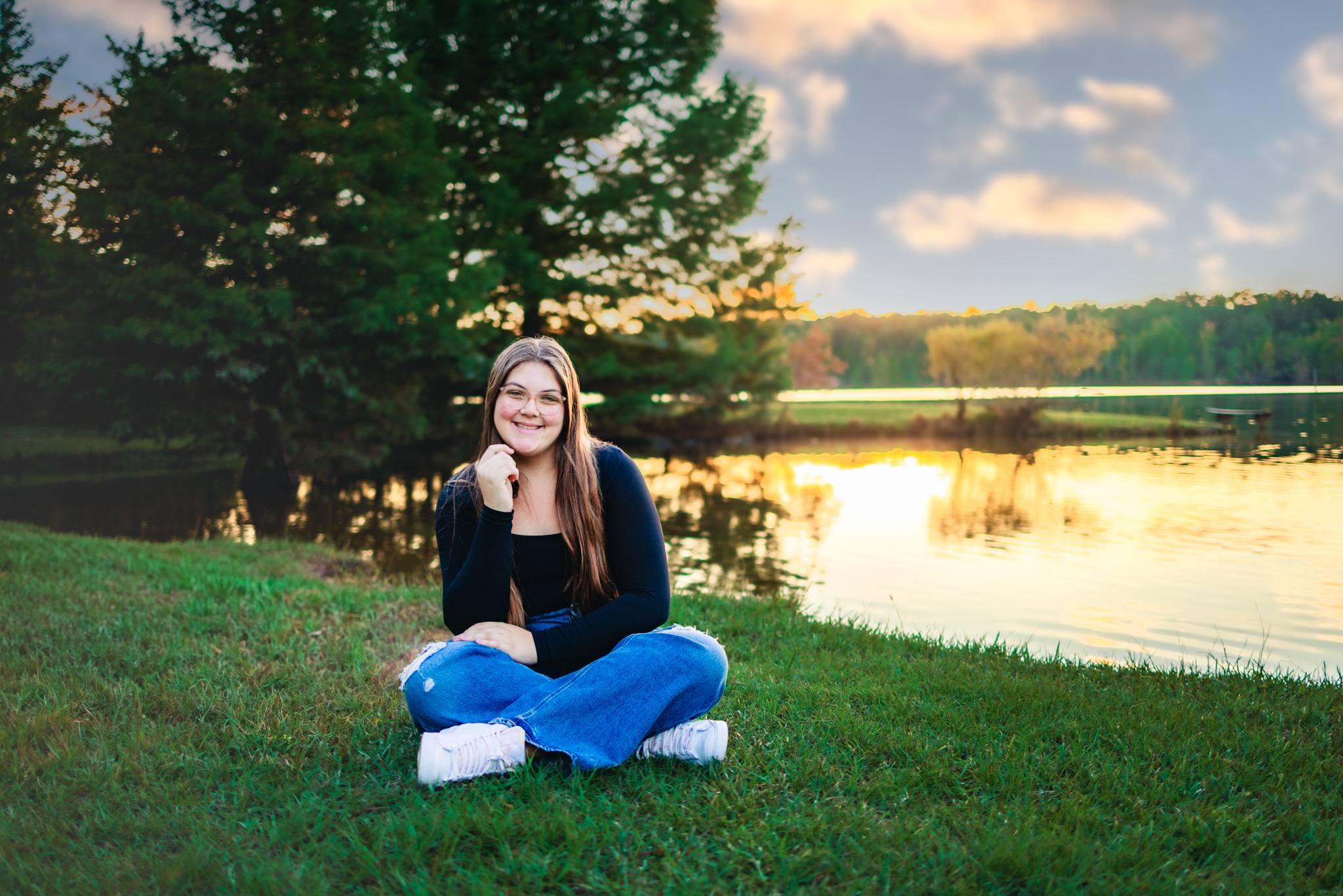 raleigh senior photographer with a senior girl sitting next to the lake