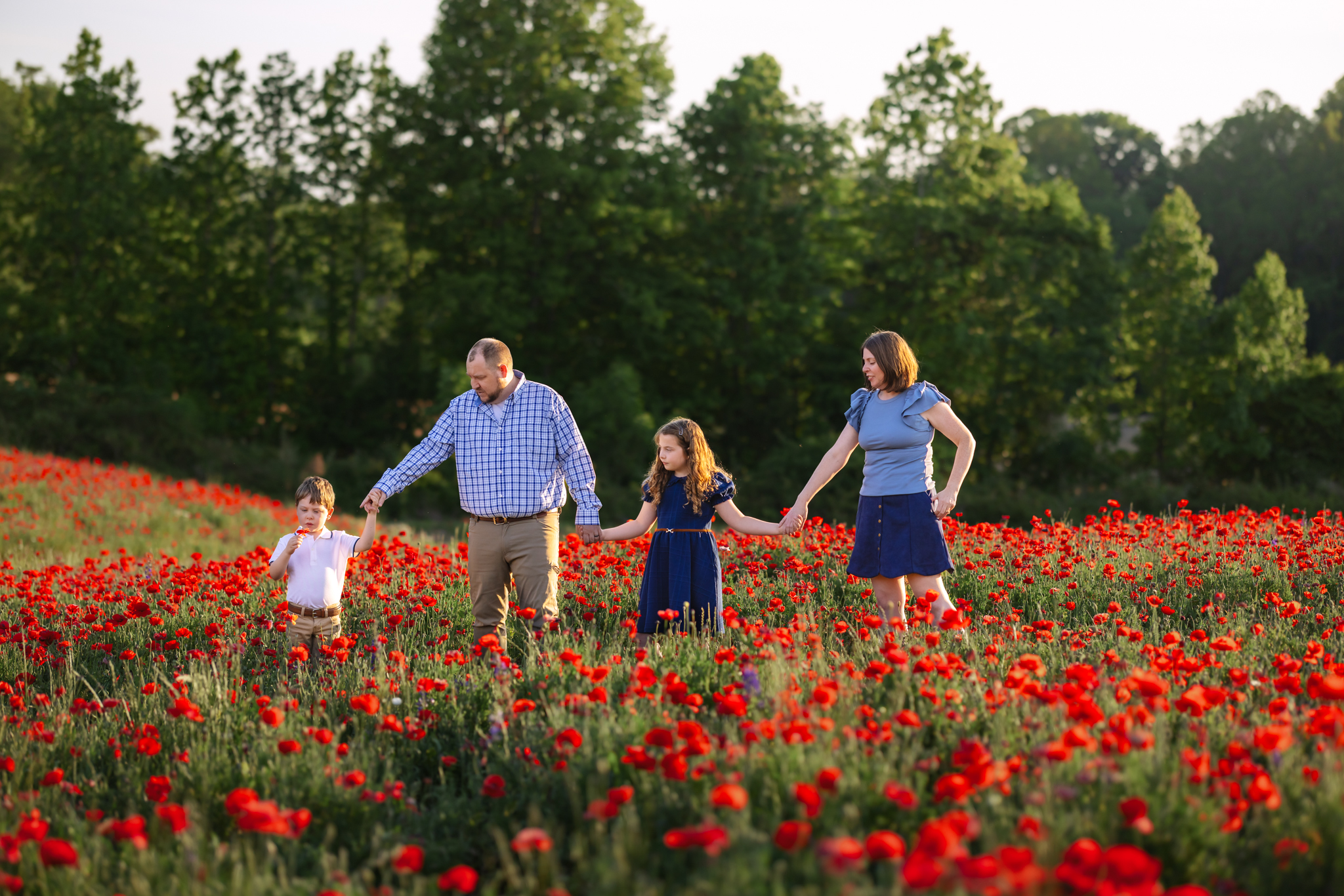 Family photo walking through the poppy fields at Dogwood Farms
