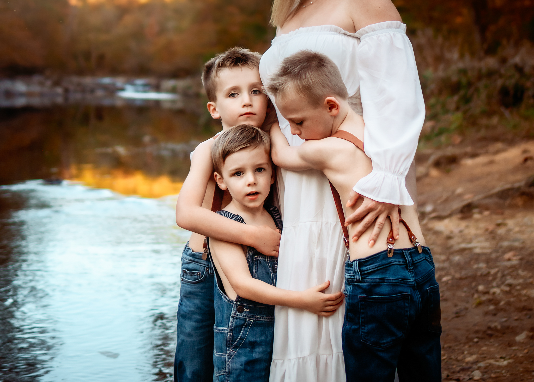 Mom holding her little boys standing near the Eno River. Riverside Mini Sessions Raleigh NC